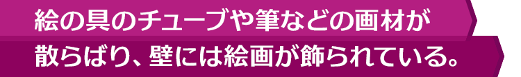 絵の具のチューブや筆などの画材が散らばり、壁には絵画が飾られている。